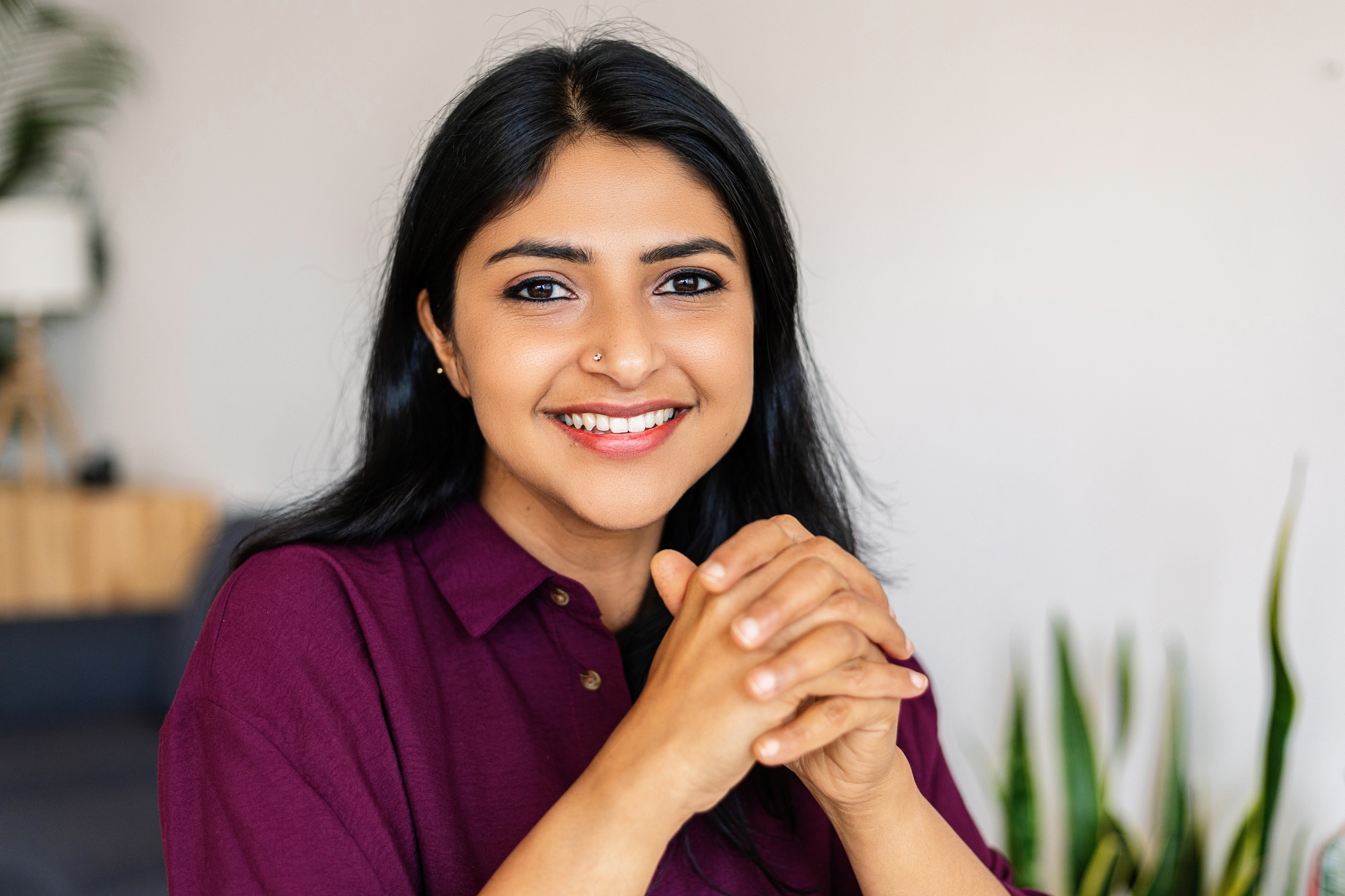 Portrait of young indian woman smiling at camera relaxing at home